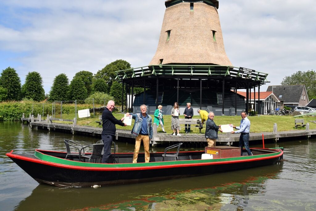 Overhandiging historisch vaarkaart op boot voor molen in Enkhuizen